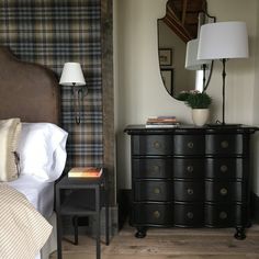 a bed room with a neatly made bed and a night stand next to a dresser