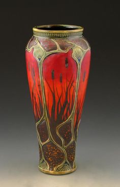 a red and gold vase sitting on top of a table