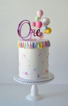 a birthday cake decorated with balloons and the number one