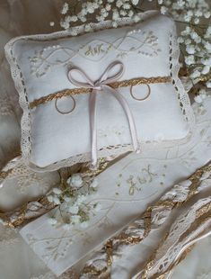 two white pillows with bows and lace on them