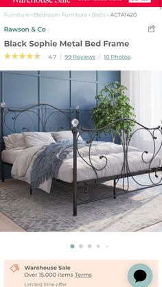 the bed frame is black and has an iron frame with metal details on it, as well as a potted plant