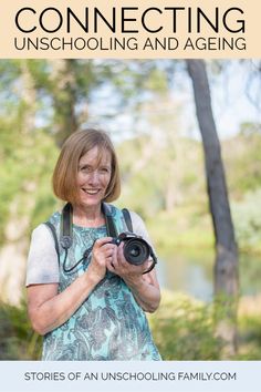 an older woman holding a camera in front of trees with the words connecting unschooling and aging