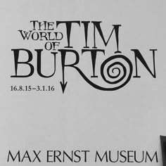 a man standing in front of a sign that says the world of tim burton