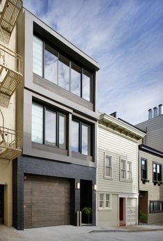 two story townhouses with stairs leading up to the second floor and another building on the other side