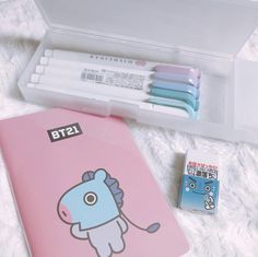 a pink box containing pens, markers and an eraser with a cartoon horse on it