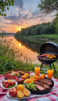 a picnic table with food and drinks on it next to the water at sunset or sunrise