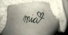 the word mia written in cursive ink on a woman's lower back