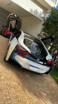 the bmw concept car is parked in front of a house