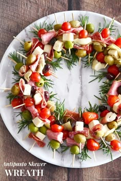 a white plate topped with meat and veggies on skewers