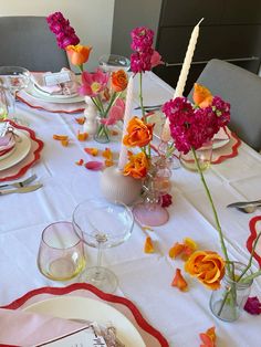 the table is set with pink and orange flowers