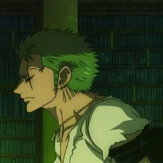 a man with green hair standing in front of a bookshelf