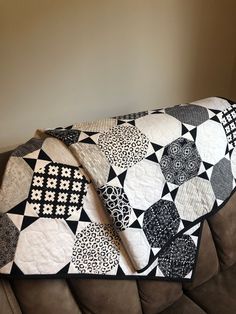 a black and white patchwork quilt sitting on top of a couch