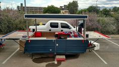 a white truck parked in a parking lot next to a table with food on it