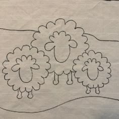 two sheep are standing in the middle of a line on a piece of cloth that has been stitched together