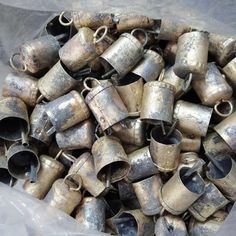 a pile of old metal cups sitting on top of a plastic bag