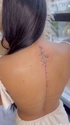 a woman with a flower tattoo on her back