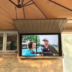 a large screen tv mounted to the side of a building