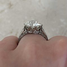 a close up of a person's hand holding an engagement ring