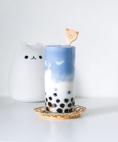 a cup that has some kind of animal in it on a plate next to a cat mug