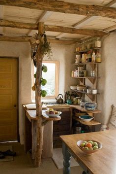 a kitchen with a tree in the middle of it and lots of shelves on the wall