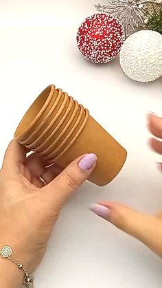 a woman is holding a cup in one hand and stacking it on the other