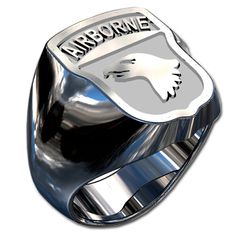 a silver ring with an eagle emblem on the front and side, sitting on top of a white background