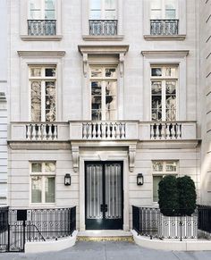 a large white building with wrought iron railings on the front door and balcony balconies