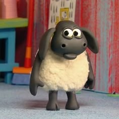 a black and white sheep standing on top of a carpet