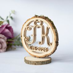 a wooden ornament with the initials k and k on it next to flowers