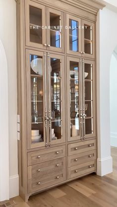 a large wooden cabinet with glass doors and drawers