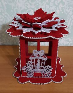 a red and white christmas card holder on a table