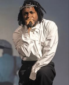 a man with dreadlocks on his head and holding a microphone to his mouth