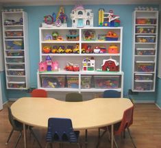 children's playroom with toy shelves and toys on the wall, along with tables and chairs