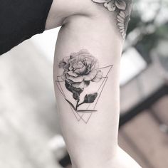 a black and white photo of a rose tattoo on the left upper half of the arm