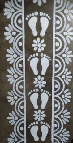 a white stencil on a brown background with footprints and flowers in the center