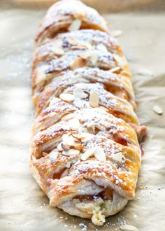 a pastry with almonds and powdered sugar on it