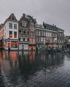 an image of a rainy day in the city with bicycles parked on the side walk