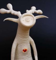 a white stuffed animal with red eyes and antlers