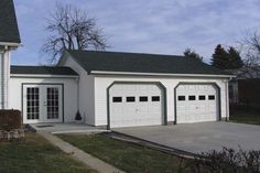 a white house with three garages and two windows