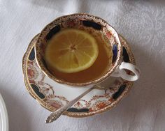 a tea cup with a slice of lemon in it