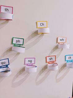 several different types of paper clips hanging on the wall next to each other with letters cut out from them