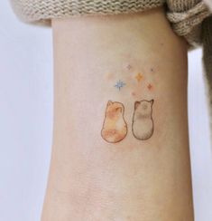 two cats tattoo on the left side of the arm, with stars in the background