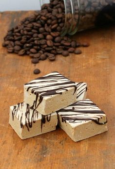 three pieces of cake sitting on top of a wooden table with coffee beans in the background