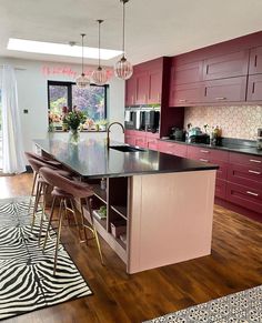 a large kitchen with an island in the middle and zebra rugs on the floor