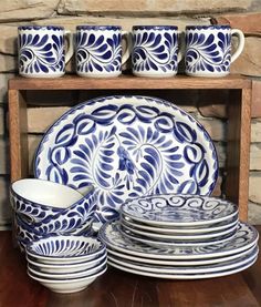 blue and white dinnerware on display in front of brick wall