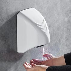 a person's hand is touching the wall mounted soap dispenser