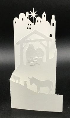 a paper cut out of a nativity scene with animals and a star on top