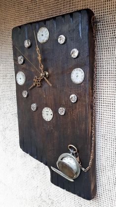 a clock made out of an old piece of wood with clocks on the face and chain attached to it