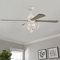 a white ceiling fan with three light bulbs on it in a room next to pictures