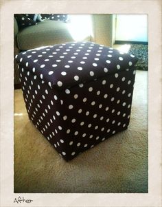 a black and white polka dot covered box sitting on the floor in front of a couch